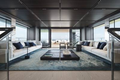 Luxurious yacht interiors blend seamlessly with the ocean view through expansive glass doors.