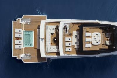 Luxurious white lounge seating and a refreshing pool adorn the expansive deck of this elegant yacht.