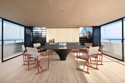 This luxurious yacht dining area offers breathtaking ocean views through floor-to-ceiling windows.