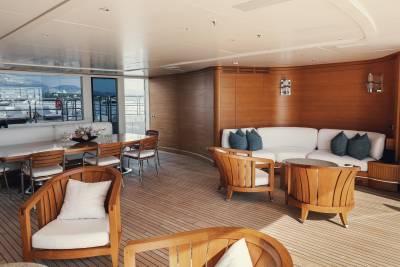 Luxurious yacht interiors blend warm wood tones with plush white seating and stunning ocean views.