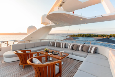 Luxurious outdoor seating on a yacht offers a perfect spot to enjoy a sunset cruise with champagne and appetizers.