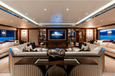 Luxurious yacht interiors offer a stunning view of the ocean from plush seating around a central entertainment system.