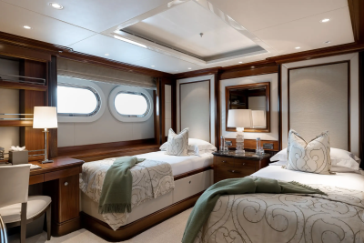 Luxurious twin beds with plush bedding and elegant wooden accents create a serene retreat in this yacht cabin.