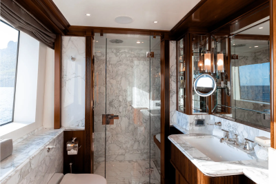 Luxurious marble and rich wood finishes create an opulent bathroom sanctuary aboard this yacht.