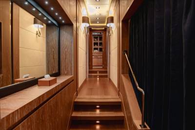 A luxurious wooden hallway with subtle lighting leads to a well-appointed room.