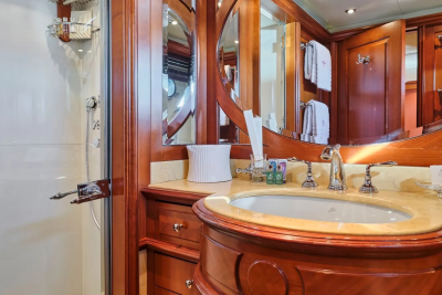Luxurious wood cabinetry and polished chrome fixtures create an opulent atmosphere in this yacht's elegant bathroom.