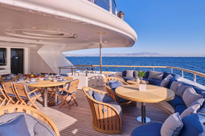 Dine al fresco on the deck of this luxurious yacht, surrounded by the sparkling blue sea and distant coastal mountains.