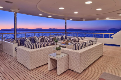 Relax on the spacious deck of this luxurious yacht as the sun sets over the tranquil sea.