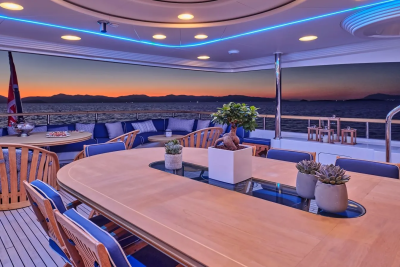 Dine al fresco on a luxurious yacht deck as the sun sets over the tranquil sea.
