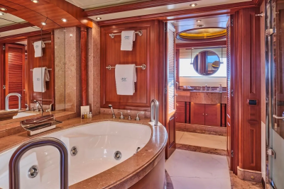 Luxurious wood-paneled bathroom features a deep soaking tub and a separate shower, all adorned with polished chrome fixtures.