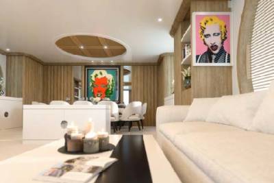 A modern living room features a plush white sofa, vibrant pop art, and a sleek dining area with elegant chairs.