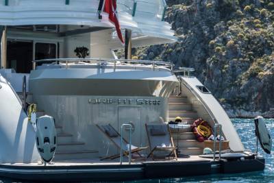 The luxurious yacht "Orient Star" rests peacefully in a sun-drenched cove, its deck ready for relaxation.