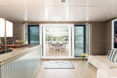 Step into this luxurious yacht's interior, where sleek modern design meets an inviting outdoor dining space.