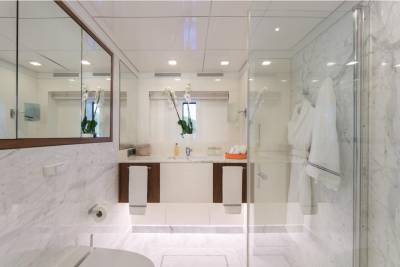Luxurious marble and glass create a serene spa-like atmosphere in this elegant yacht bathroom.