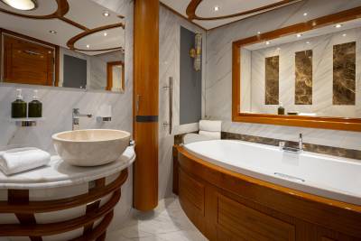 A luxurious bathroom with a freestanding bathtub, wooden vanity, and marble accents, creating a warm and elegant atmosphere.