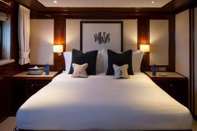 A cozy and elegant bedroom with a large, plush bed, dark wood furnishings, and decorative lighting, creating a warm and inviting atmosphere.