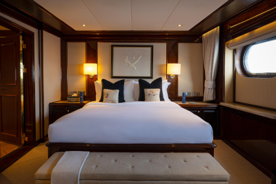 A cozy and luxurious bedroom with a large bed, wooden accents, and warm lighting, creating a comfortable and inviting atmosphere.
