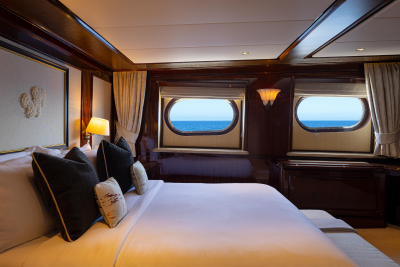 A cozy and luxurious cabin interior with large windows offering a stunning view of the ocean in the background.
