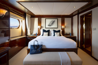 A luxurious and well-appointed bedroom with a large bed, wooden furniture, and decorative elements, overlooking a scenic view through the window.