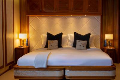 A cozy and inviting bedroom with a plush bed, wooden furniture, and decorative lighting, creating a warm and comfortable atmosphere.
