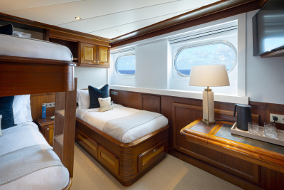 A cozy and well-furnished cabin interior with wooden paneling, a bed, and various furnishings and decor elements.