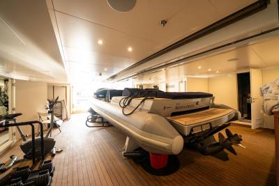 A spacious and well-equipped interior of a recreational vehicle, featuring a large boat-like structure in the foreground and various storage compartments and equipment in the background.