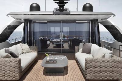 A luxurious outdoor seating area on the deck of a sleek, modern yacht, overlooking the open sea.