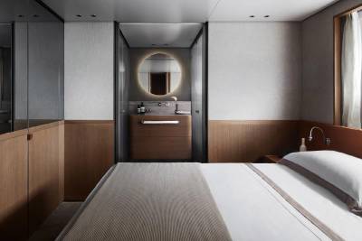 A modern and minimalist bathroom with a vanity, mirror, and a large window providing natural light.