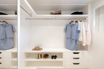 A well-organized closet with hanging clothes, shelves, and storage drawers, creating a neat and tidy space.