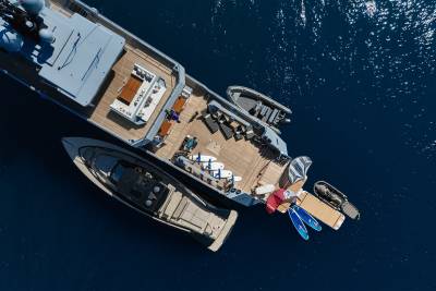 A large boat with various equipment and gear visible on its deck, surrounded by deep blue waters.