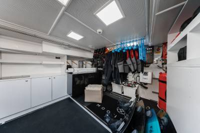 A well-organized and equipped interior of a vehicle, with various storage compartments, shelves, and hanging gear, suggesting it is likely a specialized utility or service vehicle.