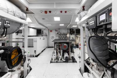 A cluttered and cramped interior space filled with various equipment, tools, and storage compartments, suggesting a utility or service vehicle.