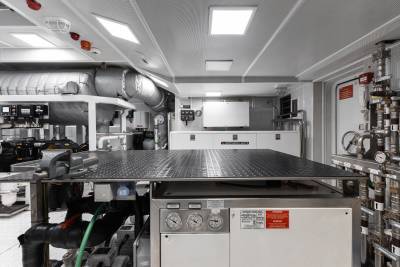 A commercial kitchen with various cooking equipment, shelves, and appliances arranged in an organized manner, creating a functional and well-equipped workspace.