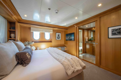 A luxurious bedroom with a plush bed in the foreground and a glimpse into an en-suite bathroom in the background.