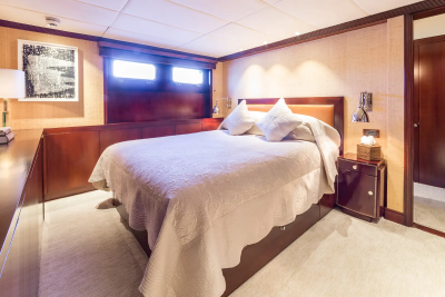 A luxurious bedroom with a plush bed in the foreground and a doorway leading to another room in the background.