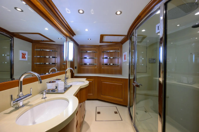 A luxurious bathroom with a double vanity in the foreground and a spacious shower stall in the background.