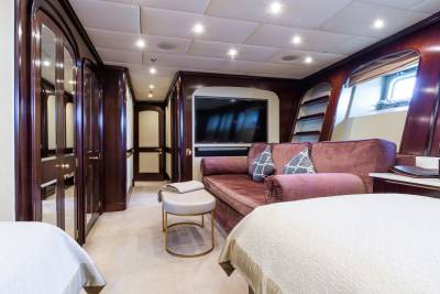 Two beds are in the foreground, with a plush sofa and entertainment center in the background.