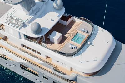 A luxurious white yacht with a pool on its deck floats on the deep blue ocean.