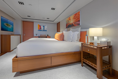 A luxurious bedroom with a large bed in the foreground and artwork on the walls in the background.