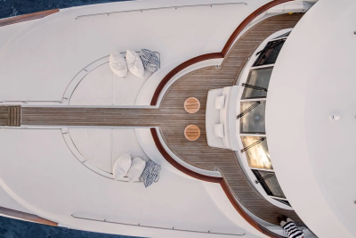 White cushions and striped pillows rest on the deck of a luxurious yacht, with the deep blue ocean visible in the background.