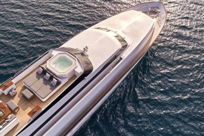 A luxurious yacht with a jacuzzi and seating area on its deck cruises through the deep blue ocean.