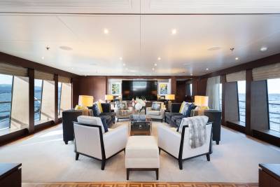 A luxurious yacht lounge with plush seating and large windows overlooking the ocean.