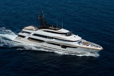 A luxurious white and gold yacht cruises through the deep blue ocean, leaving a white wake behind it.