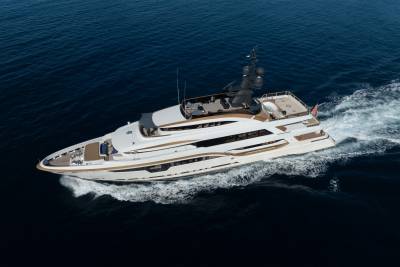 A luxurious white and gold yacht cruises through the deep blue ocean, leaving a white wake behind it.