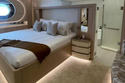 A luxurious bedroom with a large bed in the foreground and a glimpse of a bathroom in the background.