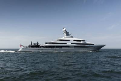 A large, modern yacht cruises on calm, blue water under a clear sky.