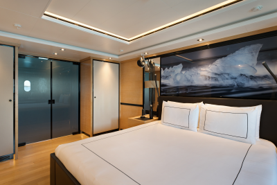 A luxurious bedroom with a large bed in the foreground and a striking ice-themed mural on the wall in the background.