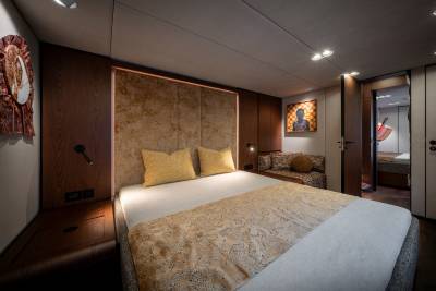 A luxurious bedroom with a plush bed in the foreground and an open doorway revealing another room in the background.
