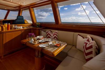 A breakfast table is set on a yacht's deck, with a serene ocean view in the background.