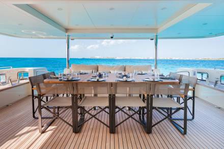 Dine al fresco on a luxury yacht's deck, surrounded by the vibrant turquoise waters of the Caribbean.